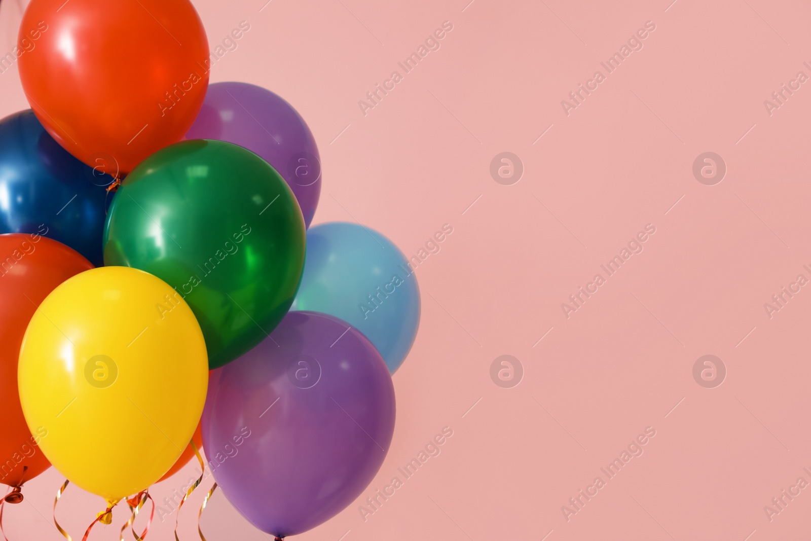 Photo of Bunch of bright balloons on color background, space for text. Celebration time