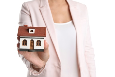 Real estate agent holding house model on white background