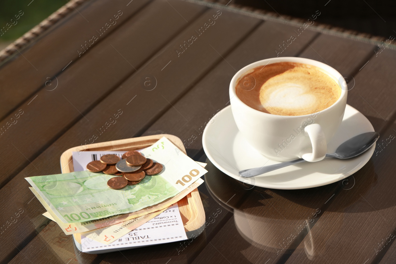 Photo of Tasty hot coffee and payment for order on table. Leave tip