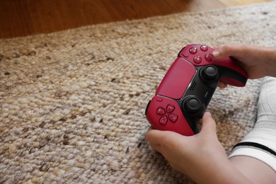 Photo of Child playing video games with controller indoors, closeup. Space for text