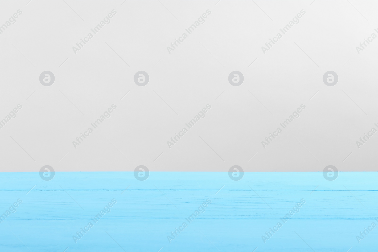 Photo of Empty light blue wooden surface on white background. Space for text