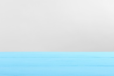 Photo of Empty light blue wooden surface on white background. Space for text