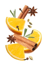 Cut orange and different spices falling on white background. Mulled wine ingredients