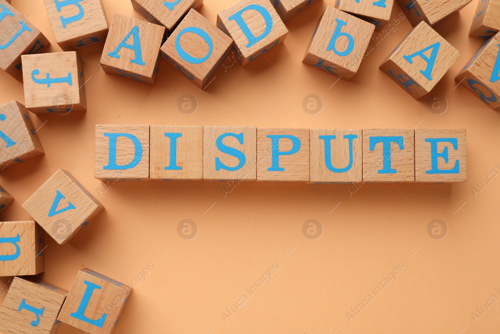 Photo of Cubes with word Dispute on pale orange background, flat lay