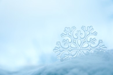 Photo of Beautiful decorative snowflake in white snow, outdoors. Space for text