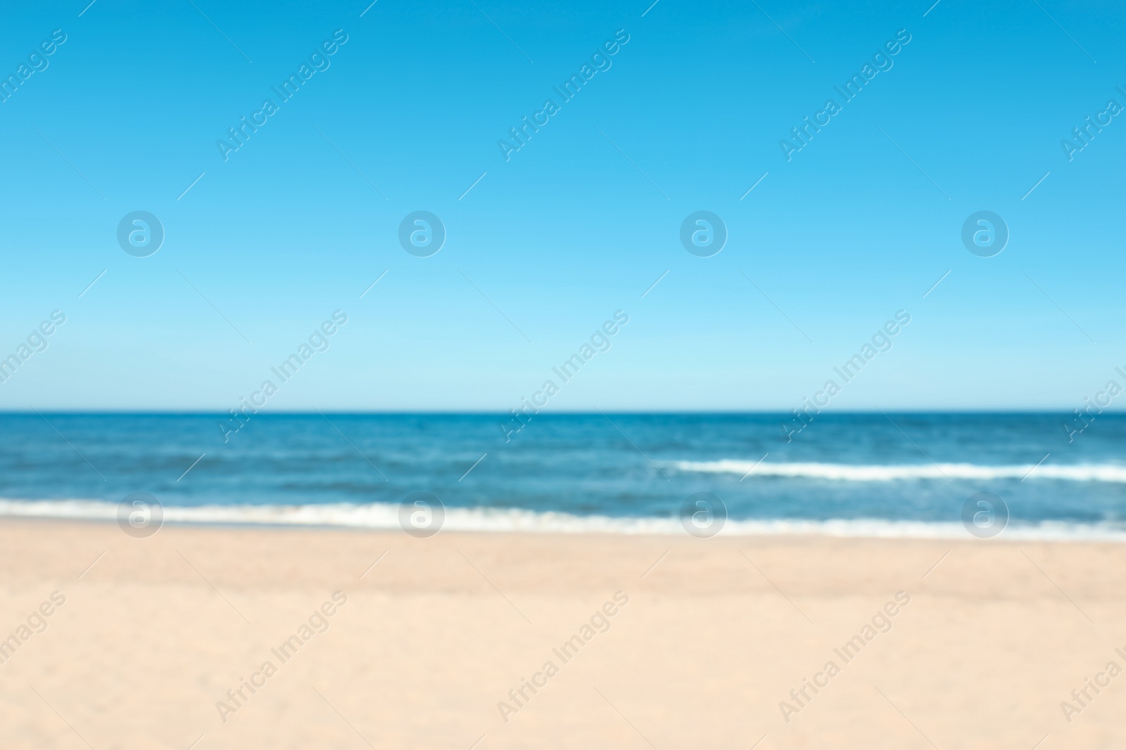 Photo of Blurred view of beautiful sea and sandy beach on sunny day