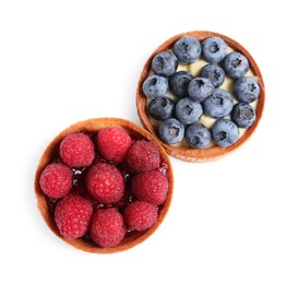 Photo of Tartlets with different fresh berries isolated on white, top view. Delicious dessert