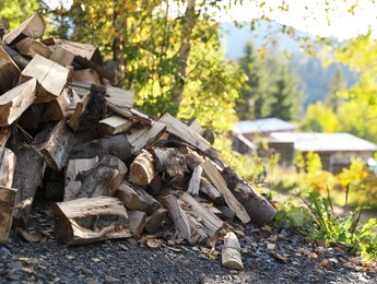 Pile of dry firewood on ground outdoors