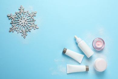 Photo of Set of cosmetic products on blue background, flat lay with space for text. Winter care