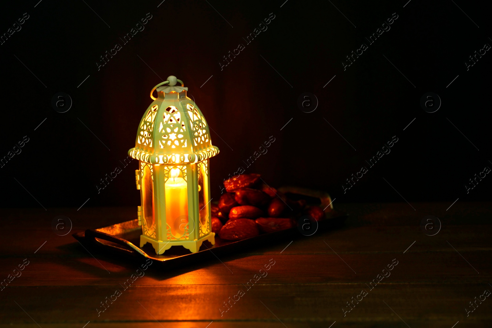 Photo of Decorative Arabic lantern and dates on table against dark background. Space for text