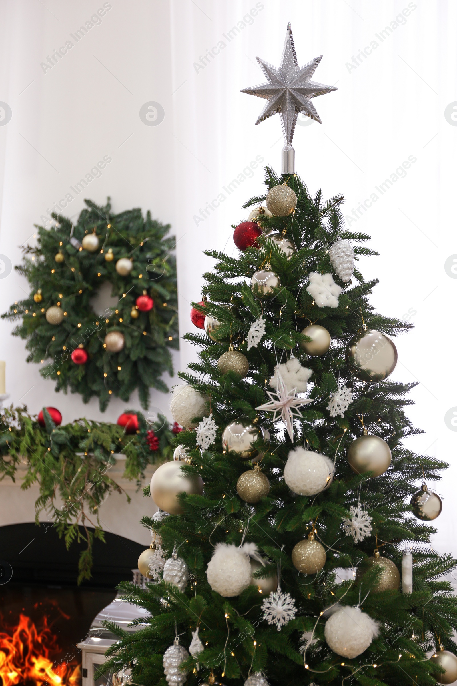 Photo of Beautiful Christmas tree with star topper in decorated room