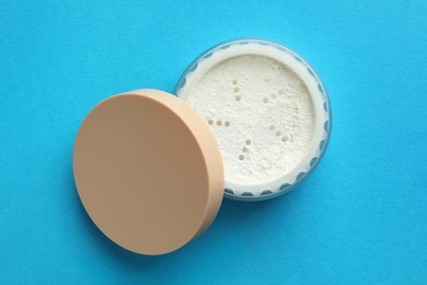 Photo of Rice loose face powder on light blue background. Makeup product