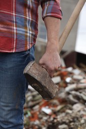 Photo of Man with sledgehammer on blurred background, closeup