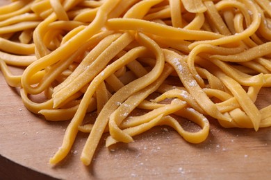 Photo of Raw homemade pasta on wooden table, closeup