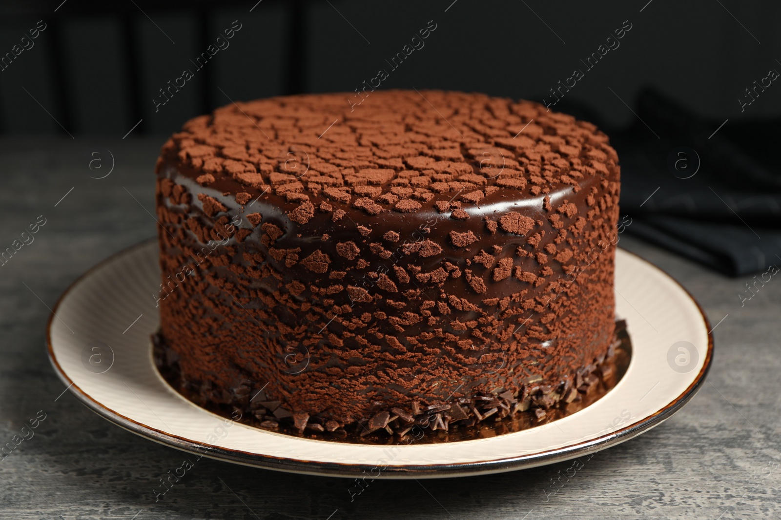 Photo of Delicious chocolate truffle cake on grey textured table