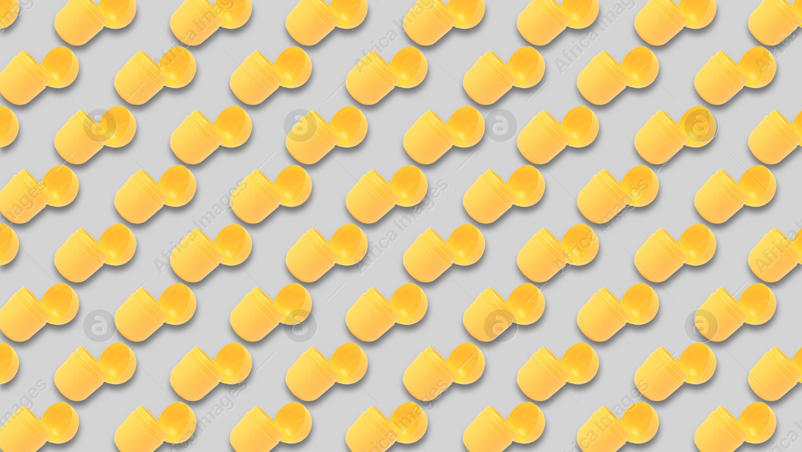 Image of Mykolaiv, Ukraine - June 26, 2023: Open yellow plastic capsule from Kinder Surprise Egg on grey background, seamless pattern design