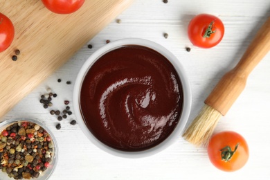 Flat lay composition with barbecue sauce on white wooden background