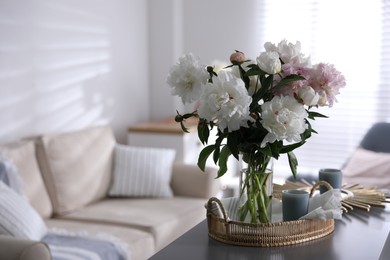 Photo of Bouquet of beautiful peony flowers on table indoors