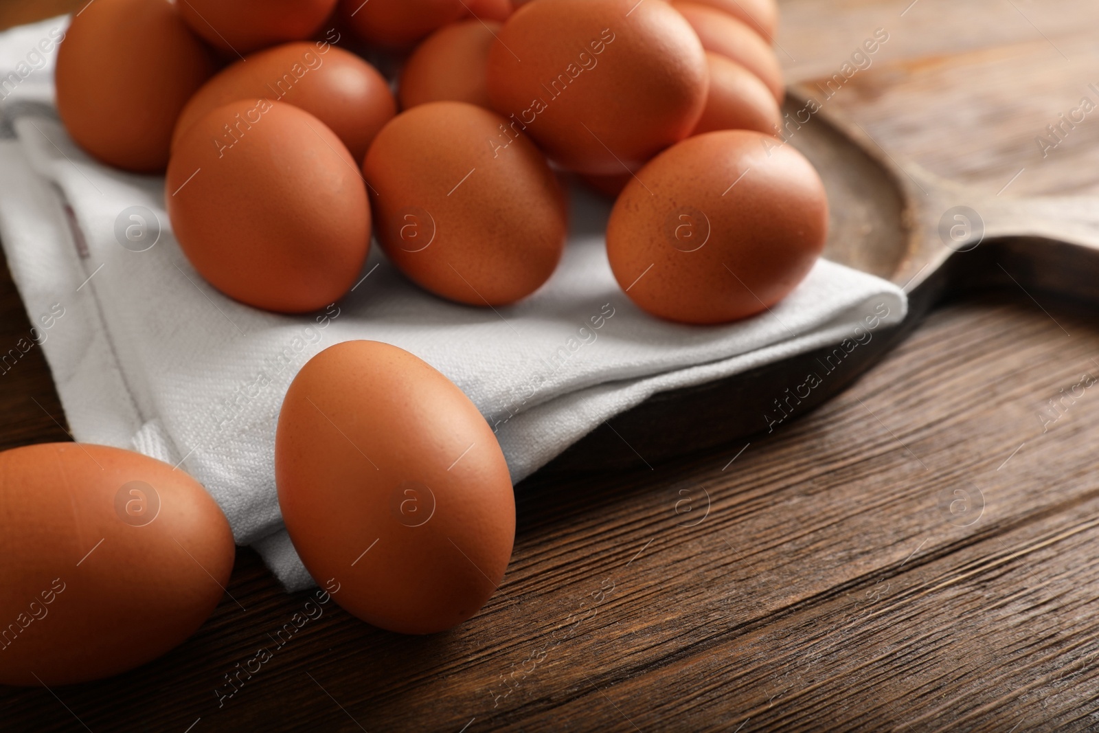 Photo of Raw brown chicken eggs on wooden table, closeup