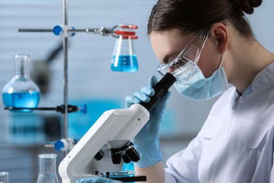 Photo of Young scientist working with microscope in laboratory