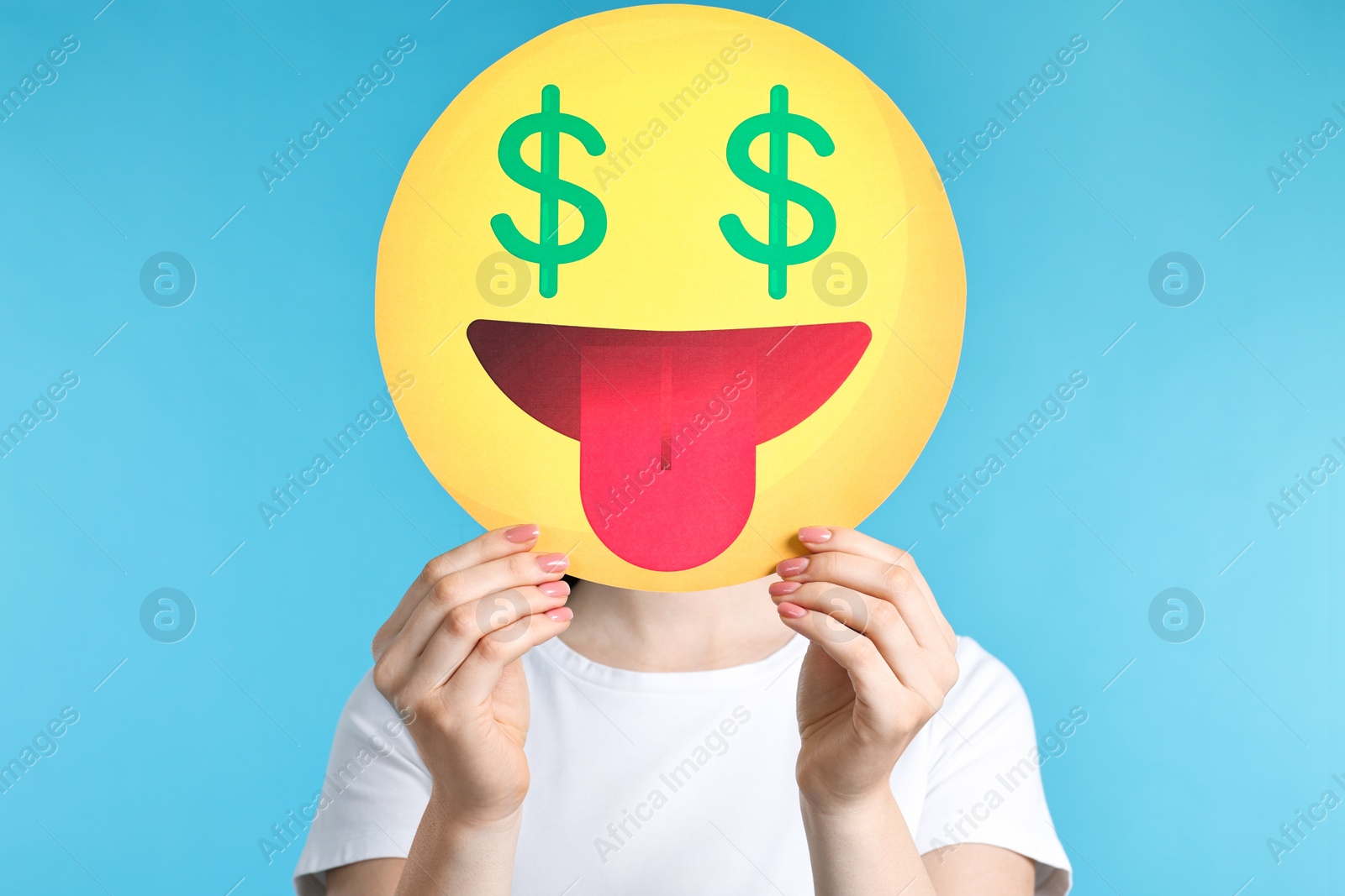 Photo of Woman covering face with dollar signs instead of eyes on light blue background