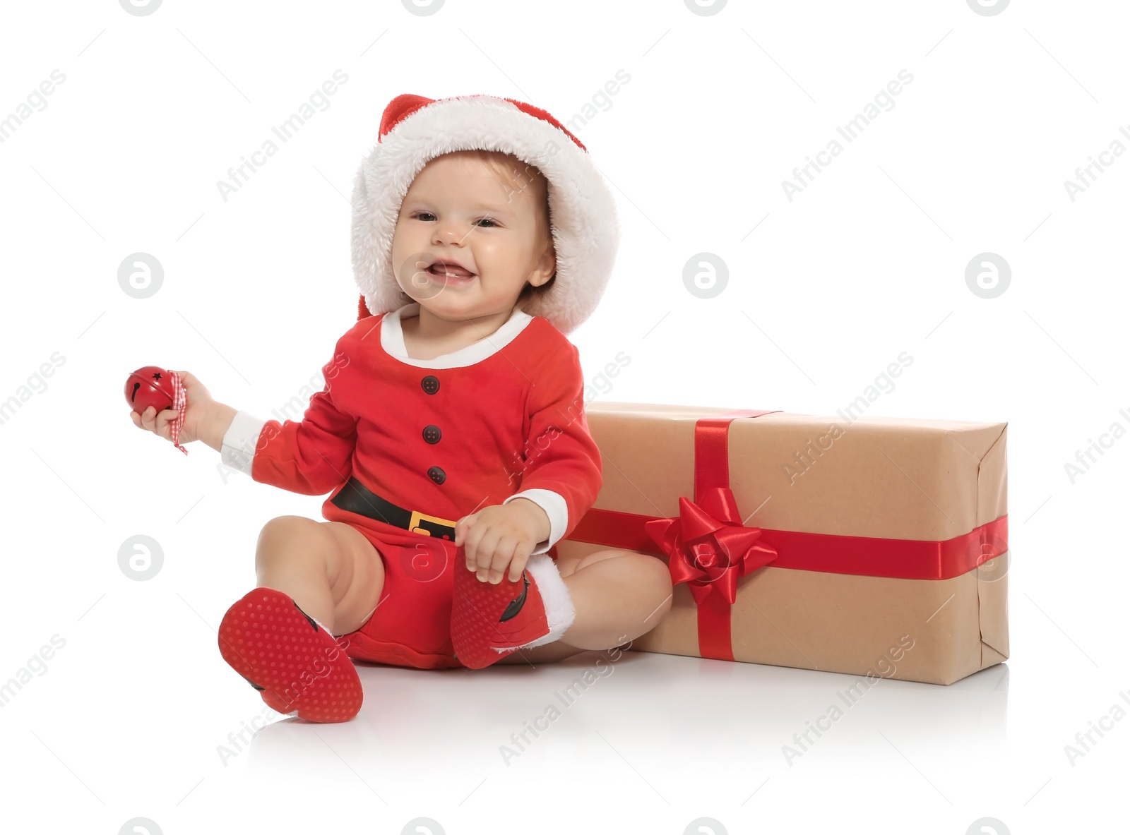 Photo of Cute little baby in Christmas costume and gift on white background