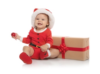 Cute little baby in Christmas costume and gift on white background