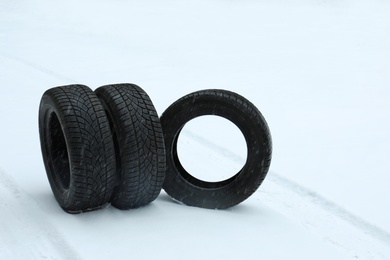 Photo of New winter tires on fresh snow. Space for text