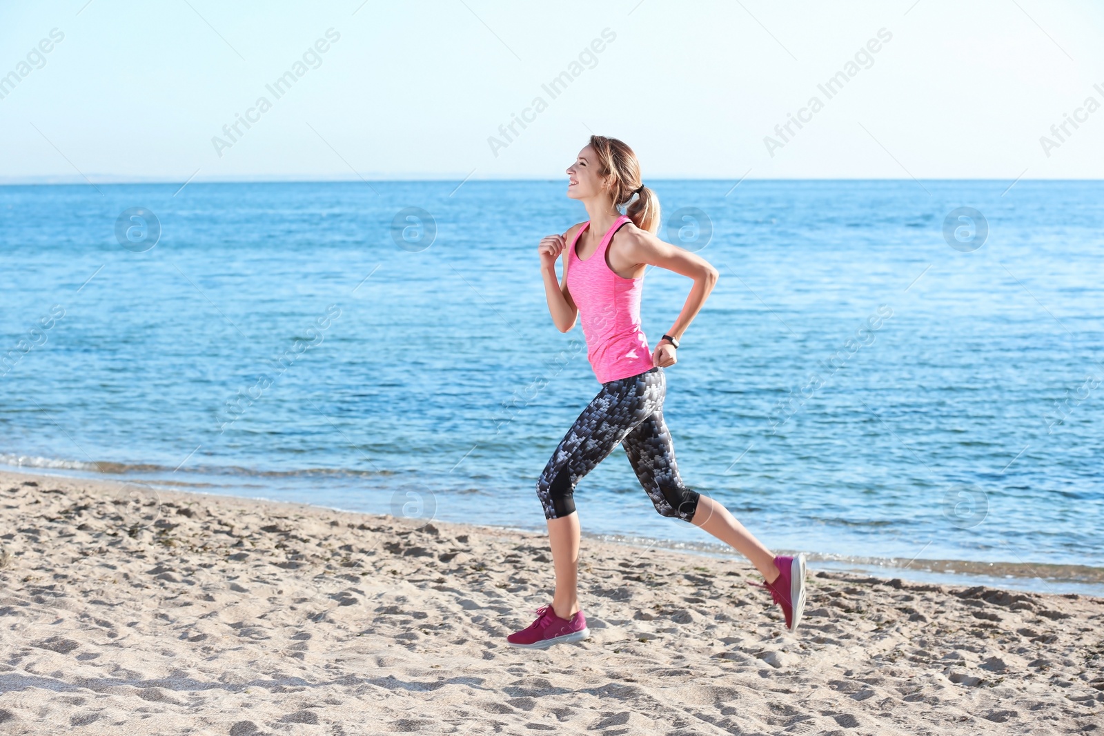 Photo of Young woman running on beach in morning