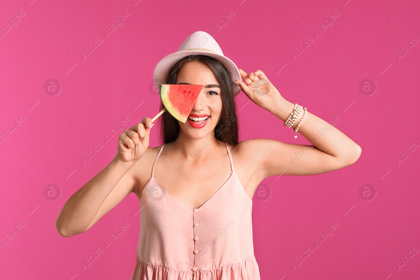 Photo of Beautiful young woman posing with watermelon on color background