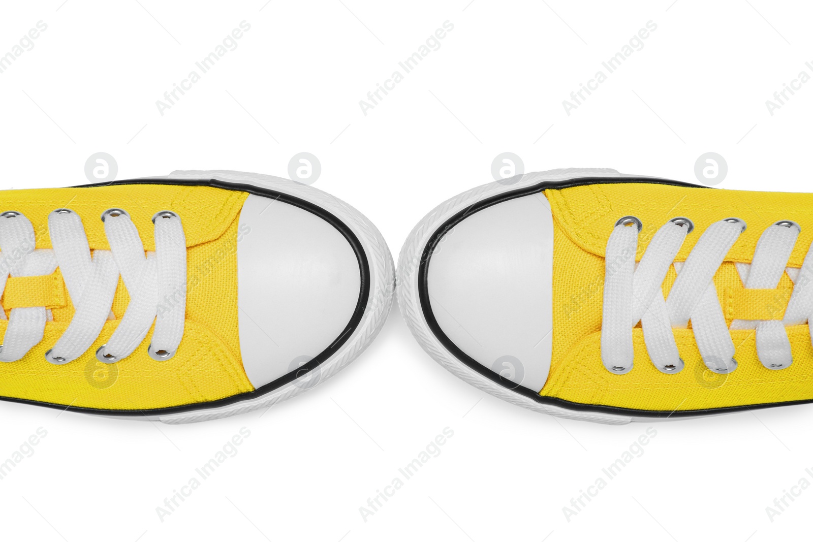 Photo of Pair of yellow classic old school sneakers isolated on white, top view