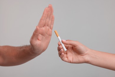 Photo of Stop smoking concept. Man refusing cigarette on grey background, closeup
