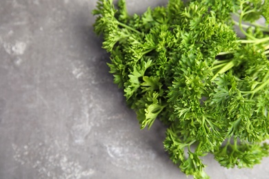 Photo of Fresh green parsley and space for text on grey background, closeup