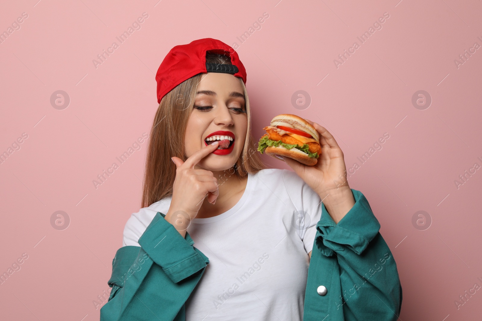 Photo of Pretty woman with tasty burger on color background