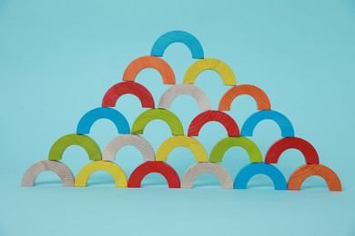 Colorful wooden pieces of playing set on light blue background. Educational toy for motor skills development