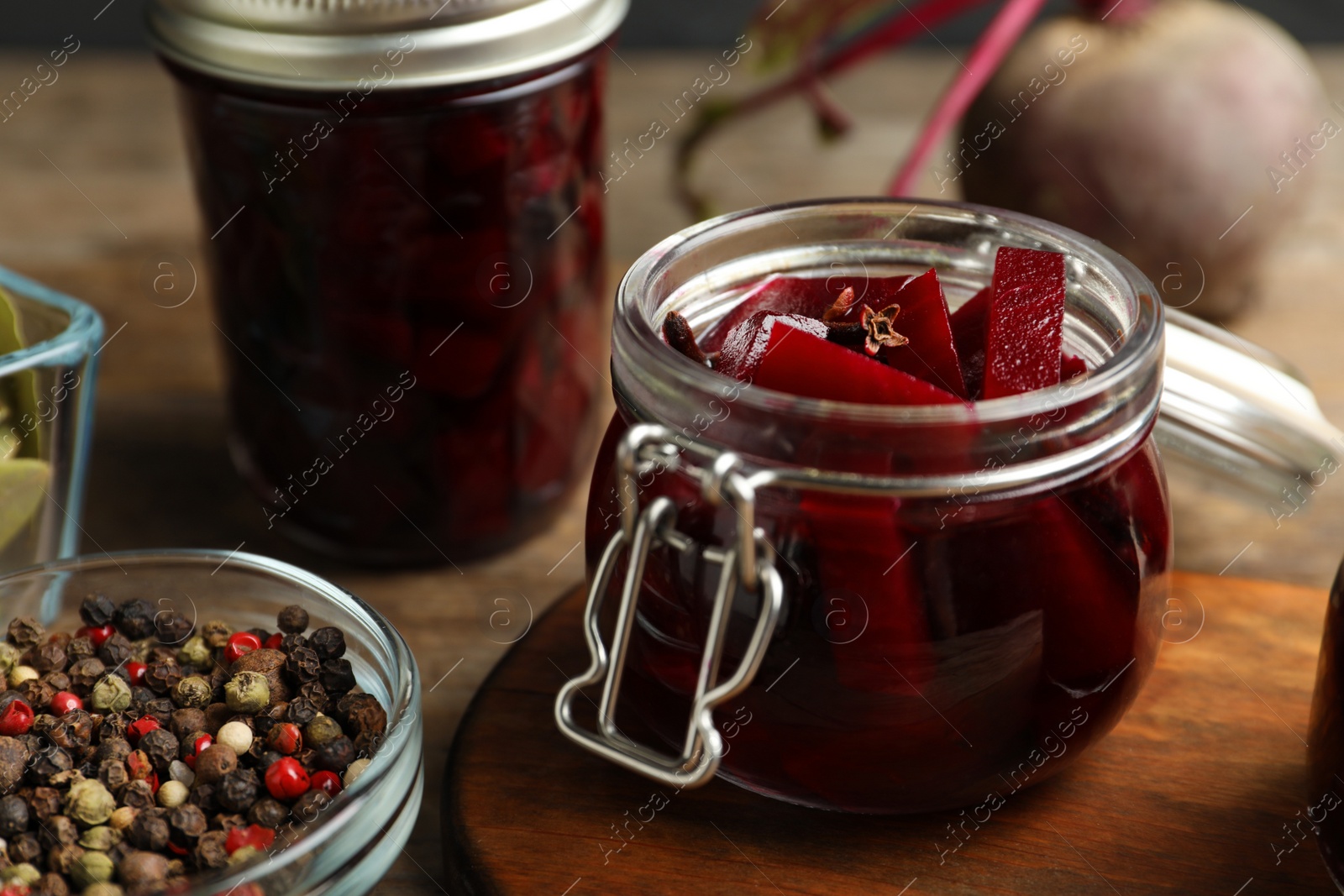 Photo of Delicious pickled beets and spices on wooden table, closeup