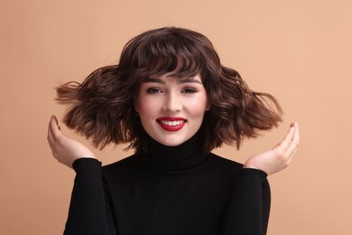 Photo of Portrait of beautiful young woman with wavy hairstyle on beige background