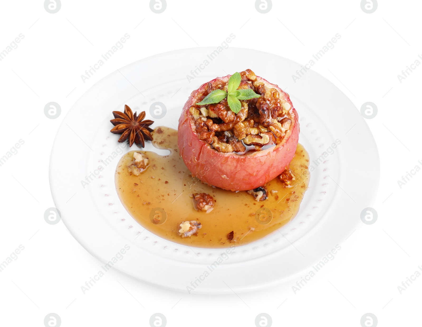 Photo of Tasty baked apple with nuts, honey and anise star isolated on white