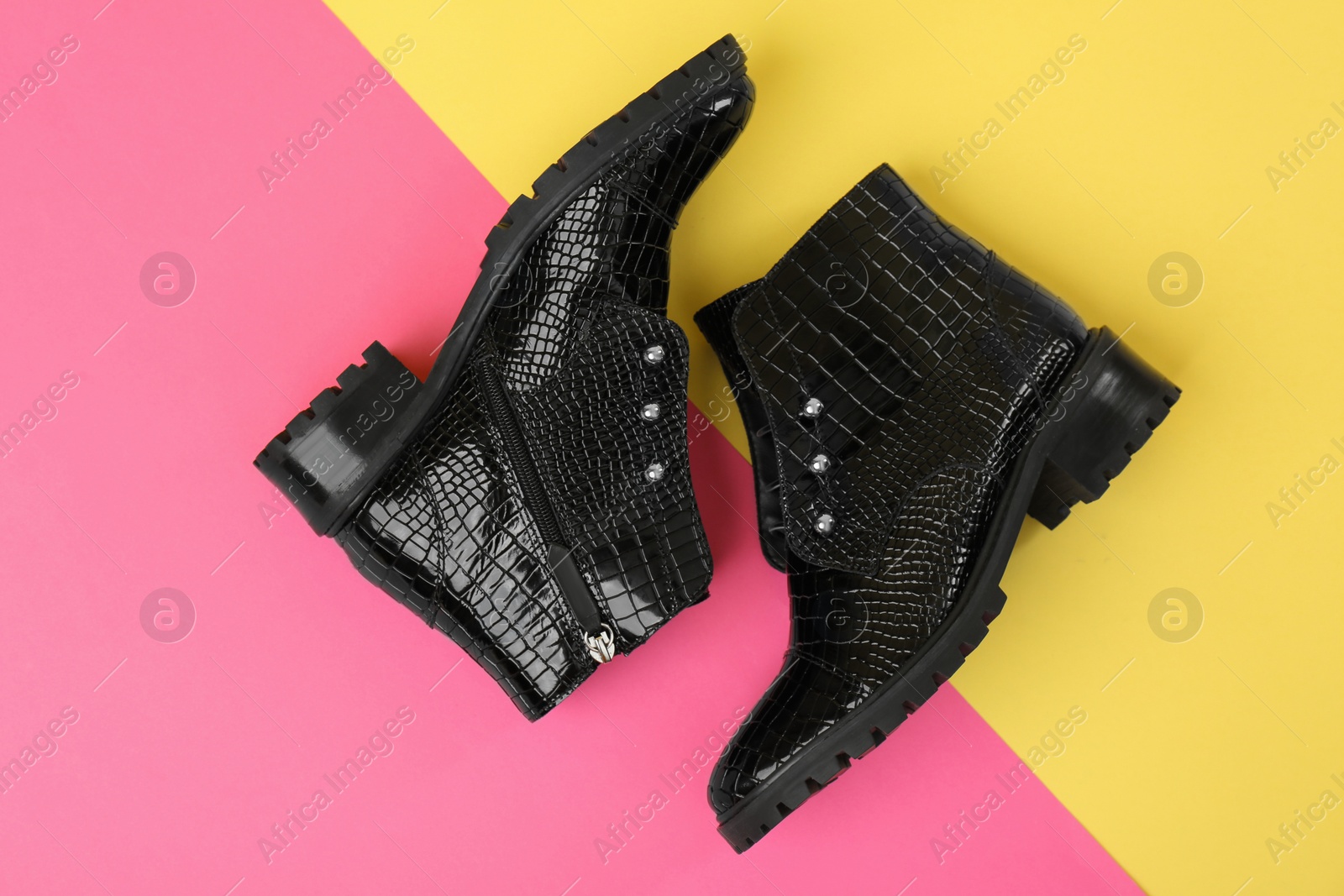 Photo of Pair of stylish ankle boots on color background, top view