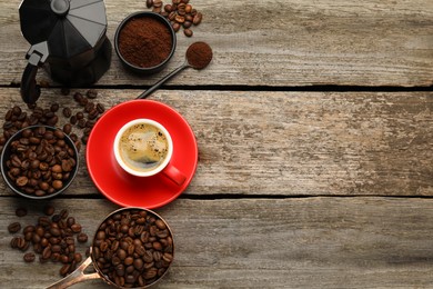 Photo of Coffee maker, beans, powder and cup of drink on wooden table, flat lay. Space for text