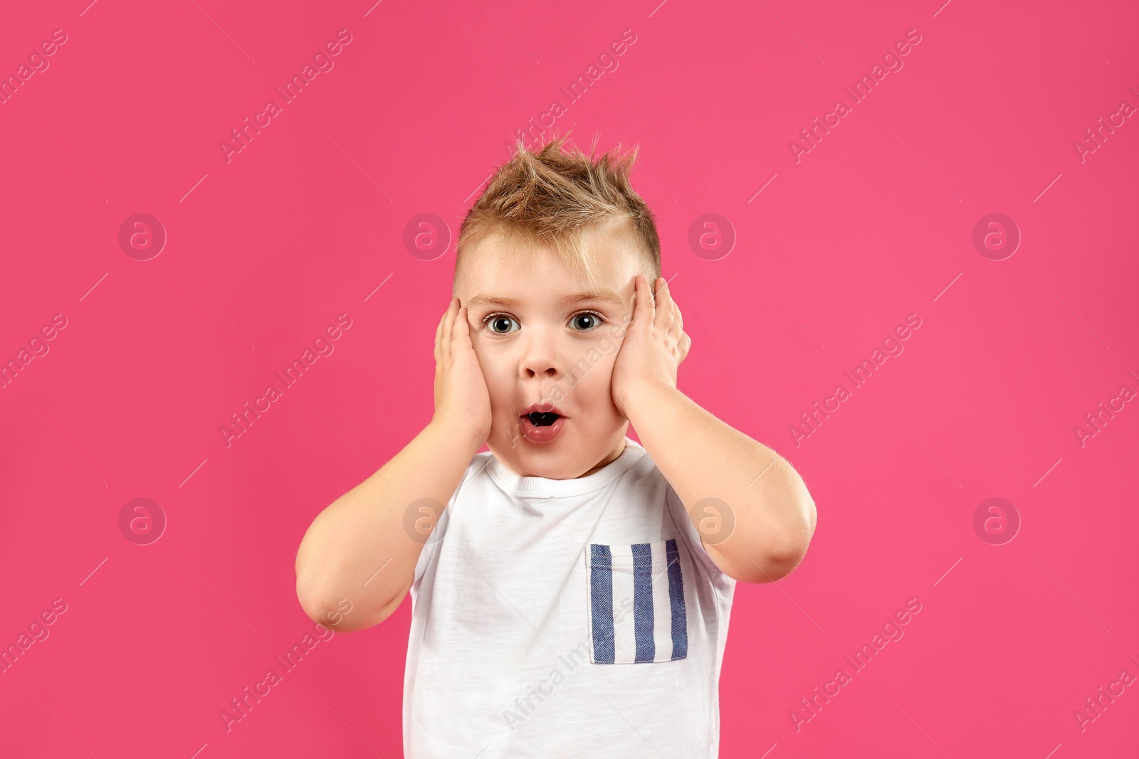 Photo of Cute little boy posing on pink background