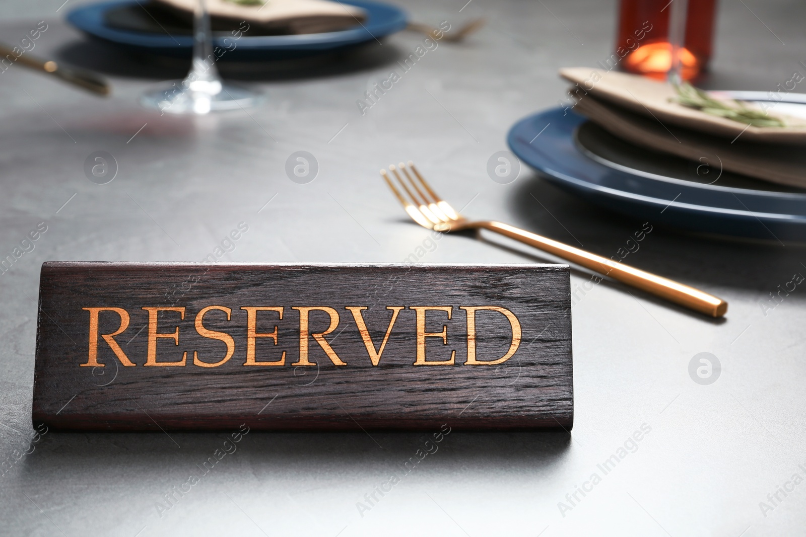 Photo of Table setting with RESERVED sign in restaurant. Space for text