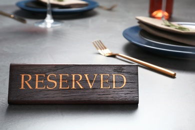 Table setting with RESERVED sign in restaurant. Space for text