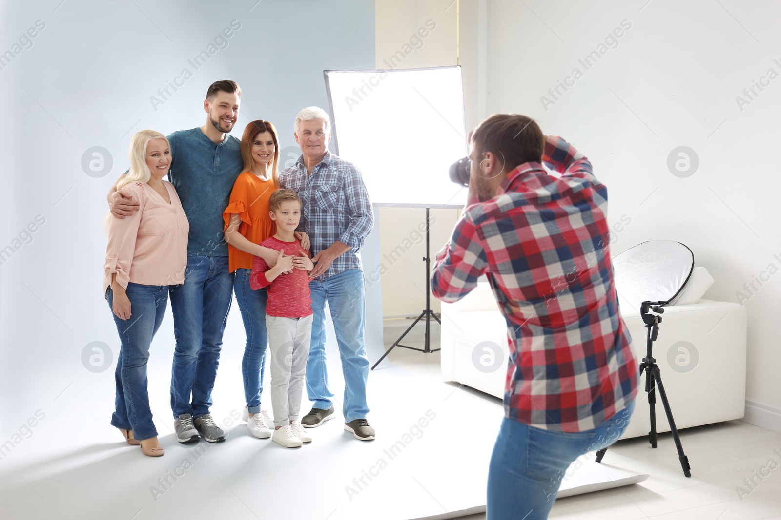 Photo of Professional photographer taking photo of family in studio