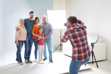 Professional photographer taking photo of family in studio