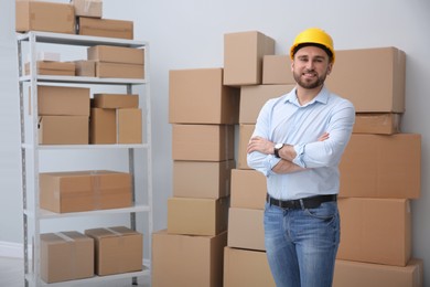 Photo of Young man near cardboard boxes at warehouse