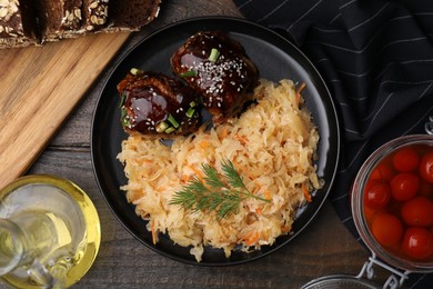 Photo of Plate with sauerkraut, chicken and products on wooden table, flat lay