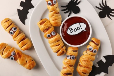 Photo of Flat lay composition with tasty sausage mummies for Halloween party on white table