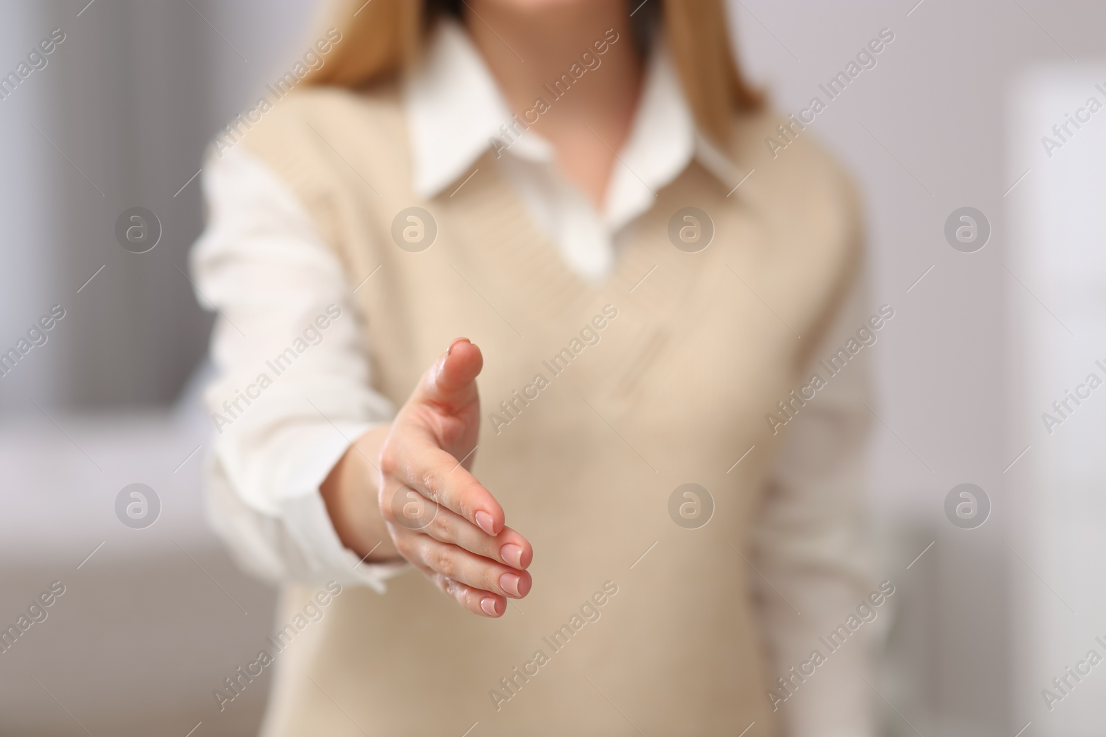 Photo of Woman offering handshake indoors, closeup. Space for text