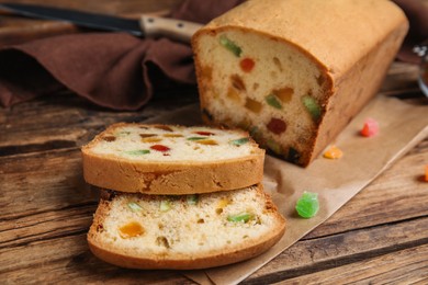 Delicious cake with candied fruits on wooden table